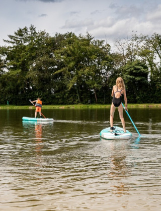 Niños en tabla de SUP en el lago, parque familiar Goolderheide, Bocholt