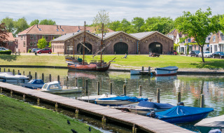 Zona portuaria en Brielle, Holanda Meridional, Países Bajos con barcos, muelle y antiguos edificios detrás.
