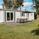 Veluwe lodge med moderne hvid facade, terrasse og have i ferieparken De Boshoek i Holland.