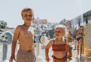 Twee jonge kinderen spelen vrolijk in het waterpark van Beerze Bulten, een vakantiepark in Overijssel.