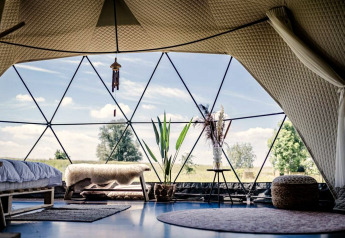 Interior of Cast Away Dome at TinyParks Cast Away, Netherlands, featuring modern decor and nature view.