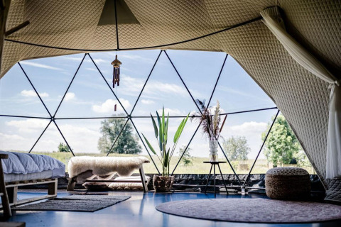 Intérieur du Cast Away Dome à TinyParks Cast Away, Pays-Bas, avec une décoration moderne et vue naturelle.