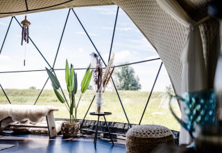 Interieur van Cast Away Dome in TinyParks Cast Away, Nederland, met gezellige meubels en veel licht.