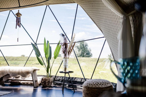 Interieur van Cast Away Dome in TinyParks Cast Away, Nederland, met gezellige meubels en veel licht.