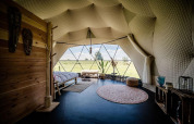 Interno della Cast Away Dome al TinyParks Cast Away nei Paesi Bassi, con ampia finestra e vista sul paesaggio.