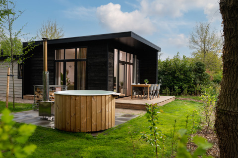 Moderna cabaña de vacaciones con jacuzzi al aire libre, terraza y jardín en Holiday Park Mölke, Overijssel.