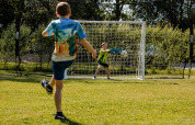 Børn spiller fodbold på en solrig dag på CharmeCamping De Regge-Vallei i Overijssel, Holland.