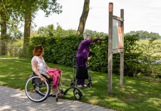 To kvinder med hjælpemidler nyder naturen ved CharmeCamping De Regge-Vallei i Overijssel, Holland.