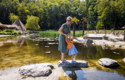 Mutter und Tochter mit Sonnenbrillen genießen den Tag am Teich im Ferienpark Cosy Cabins, Limburg, Belgien.