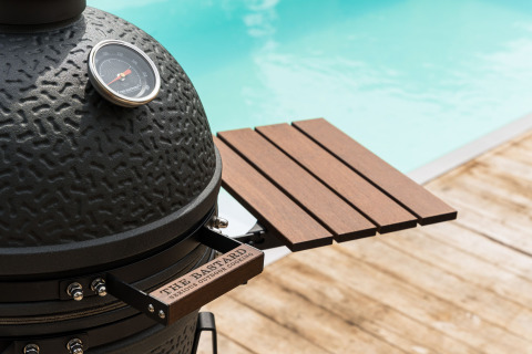 Keramikgrill mit Thermometer und Holzablage am Pool, fotografiert im Ferienpark De Weelderik in Gelderland.