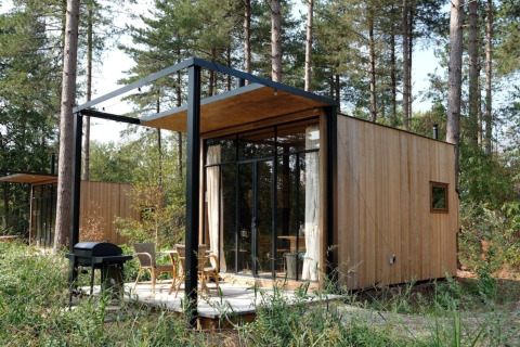 La Sweet Cabin de Cosy Cabins en los bosques de Limburg, Bélgica, una pequeña casa de madera con terraza.