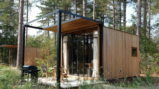De Sweet Cabin bij Cosy Cabins in het bos van Limburg, België, een tiny house met houten gevel en terras.