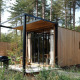 En lille Sweet Cabin ved Cosy Cabins i skovene i Limburg, Belgien, med træbeklædning og terrasse.