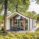 Billede af en moderne Ecovilla på Holiday park Ackersate, Nederlandene, omgivet af grønne træer og natur.
