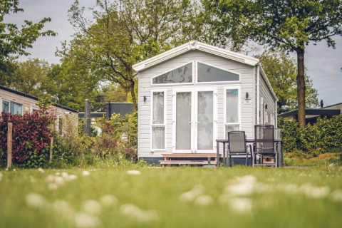 Casa pequeña en Holiday park Ackersate en los Países Bajos, rodeada de naturaleza y muebles de exterior.