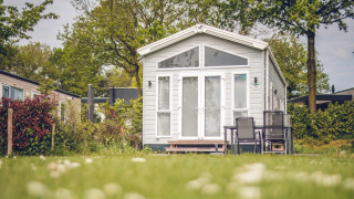 Casa pequeña en Holiday park Ackersate en los Países Bajos, rodeada de naturaleza y muebles de exterior.