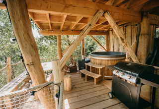 Boomhut met terras, houten hottub en barbecue bij Cosy Cabins in het bos van Limburg, België.