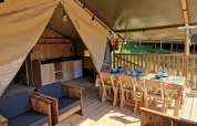 Interior de tienda safari con muebles de madera, mesa de comedor y cocina en Domaine La Sauzette, Francia.
