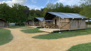 Cabañas Glamping Deluxe tipo 2 en Holiday Park Duinhoeve, Países Bajos, rodeadas de césped y senderos.
