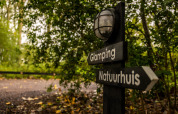 Skilt med retninger til Glamping og Naturhus, omgivet af grønt, i Buitengoed Ruysbos, Gelderland.