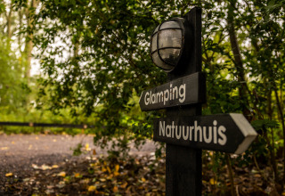 Signpost for Glamping and Nature House, surrounded by lush greenery at Buitengoed Ruysbos, Gelderland.