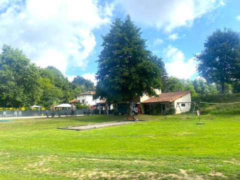 View of Moulin du Pommier Glamping & Camping holiday park in Nouvelle-Aquitaine, France with lawn and trees.
