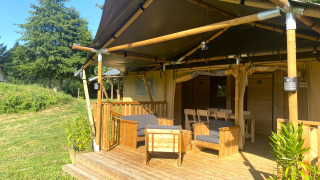 Tenda safari con veranda privata e posti a sedere al Moulin du Pommier Glamping & Camping in Francia.