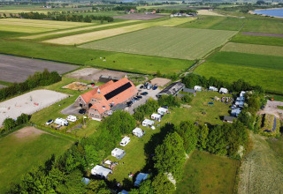 Luchtfoto van Camping Eefting in Friesland, Nederland met caravans, weilanden en boerderijgebouwen.