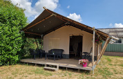 Safari-telt på Camping Eefting i Holland med træterrasse, plastikstole og blomsterpotte foran.