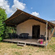 Tenda safari al Camping Eefting nei Paesi Bassi con terrazza in legno, sedie da esterno e fiori.