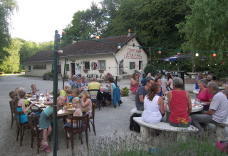 Vakantie bij Camping Les Bouleaux in Grand Est, Frankrijk, gezinnen eten gezamenlijk buiten.