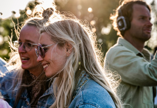Mensen genieten van een zonnige dag op TinyParks Cast Away in Zuid-Holland, Nederland, met wijn en muziek.