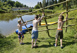 Ragazzi trasportano una zattera in acqua Camping Donnersberg a Gerbach, Renania-Palatinato, Germania