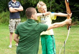 Joven aprende tiro con arco Camping Donnersberg en Gerbach, Renania-Palatinado, Alemania