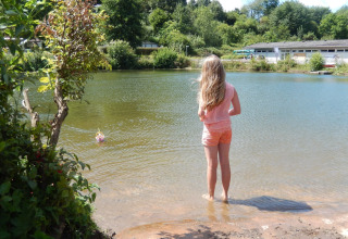 Una ragazza guarda il laghetto del Camping Donnersberg a Gerbach, Renania-Palatinato, Germania