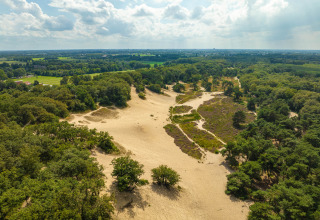 Luchtfoto van zandduinen en bos bij Sandberghe vakantiepark in Noord-Brabant, Nederland op een zonnige dag.