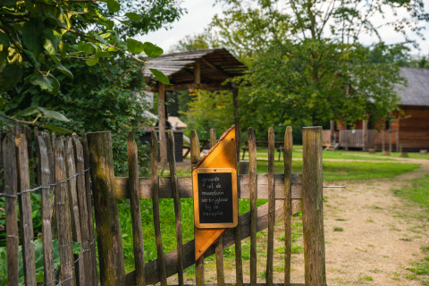 Houten hek met bord bij Sandberghe vakantiepark in Noord-Brabant, Nederland, omgeven door groen.
