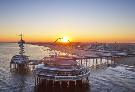 Atardecer tras una noria sobre el muelle en la playa cerca de Delft, Holanda Meridional, Países Bajos.