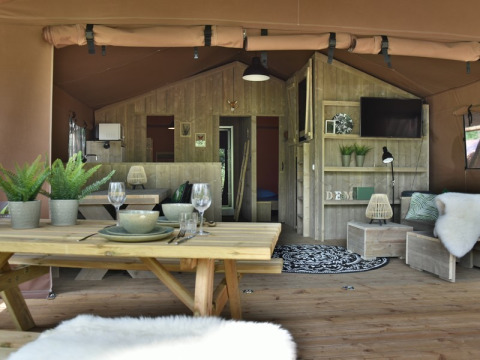 Vista del interior en Veluwe Lodge de Camping Samoza en los Países Bajos, con muebles de madera y ambiente cálido.