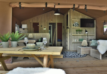 Vista del interior en Veluwe Lodge de Camping Samoza en los Países Bajos, con muebles de madera y ambiente cálido.