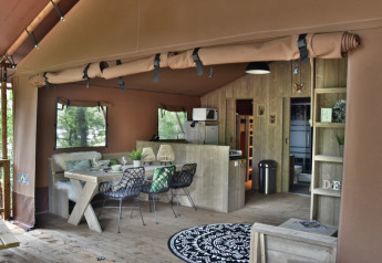 Interior de una acogedora cabaña en Veluwe Lodge en Camping Samoza, Países Bajos, con decoración rústica.