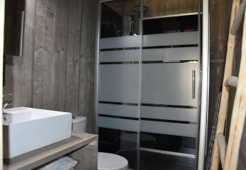 Baño moderno en Veluwe Lodge de Camping Samoza, Países Bajos, con ducha, inodoro y lavabo visibles.