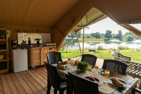 Vista interior de la tienda Safari tent of Excellent Maaszicht en Camping de Boomgaard, Bélgica, junto al lago.