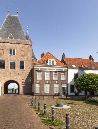Historic gateway and cobblestone square near Dronten, Flevoland, Netherlands, with traditional Dutch buildings.