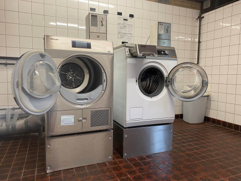 Laundry room with open washing machines and dryers at Camping Jagtveld in South Holland, Netherlands.