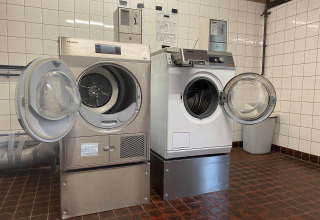 Wasserette met open wasmachines en droogkasten bij Camping Jagtveld, Zuid-Holland, Nederland.