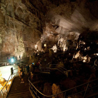 Des visiteurs explorent une grotte éclairée près de Senigallia, Marches, Italie, sur des passerelles sinueuses.