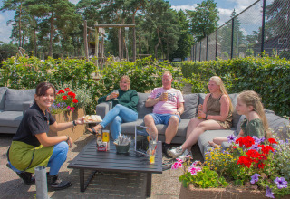 Gezellige familiesfeer op Camping Samoza in Gelderland, Nederland, met buitenzitje en bediening.
