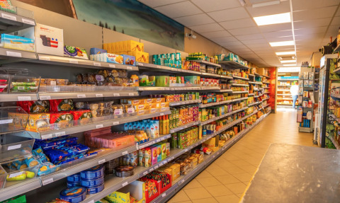Binnenzicht van een supermarkt in vakantiepark Bad Hoophuizen, Gelderland, met gevulde winkelrekken.