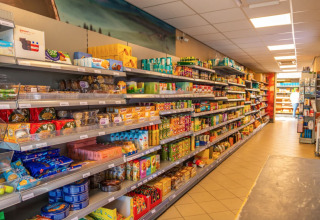 Binnenzicht van een supermarkt in vakantiepark Bad Hoophuizen, Gelderland, met gevulde winkelrekken.